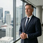 Portrait d'un homme d'affaires influent en costume sombre regardant un horizon urbain, évoquant les rumeurs sur le mariage d'Elon Musk en 2025